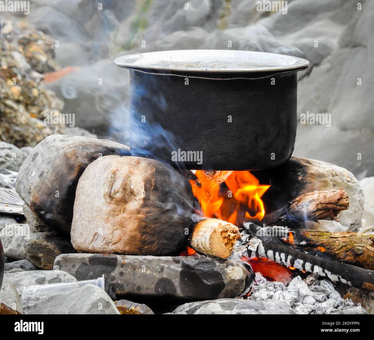 Un gros plan de Cooking en plein air dans la forêt. Un pot ragoût sur un poêle à feu fait de pierre et de bois comme combustible. Uttarakhand Inde. Banque D'Images