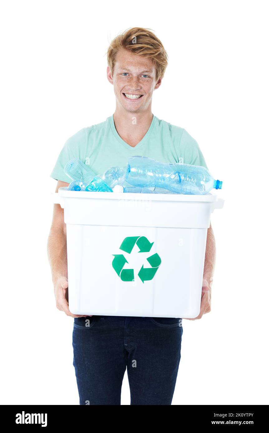Recyclage : c'est la bonne chose à faire. Un jeune homme heureux à tête rouge tenant un bac de recyclage rempli de bouteilles en plastique vides. Banque D'Images