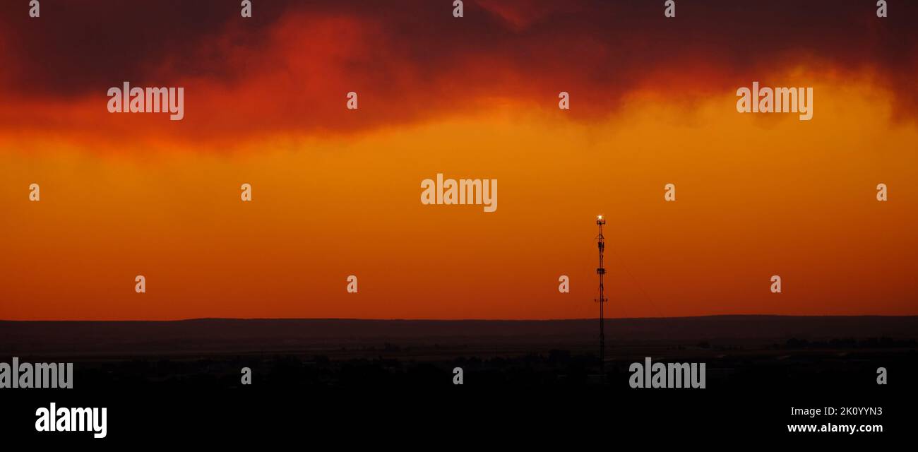 Silhouette de tour de cellules au coucher du soleil sur la ligne d'horizon pour la communication numérique Banque D'Images