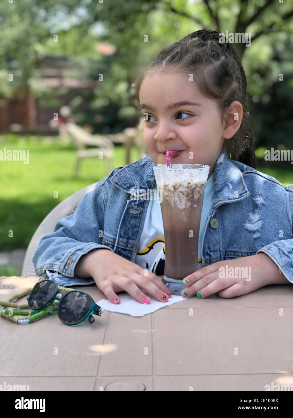 la fille boit du milk-shake dans le jardin Banque D'Images
