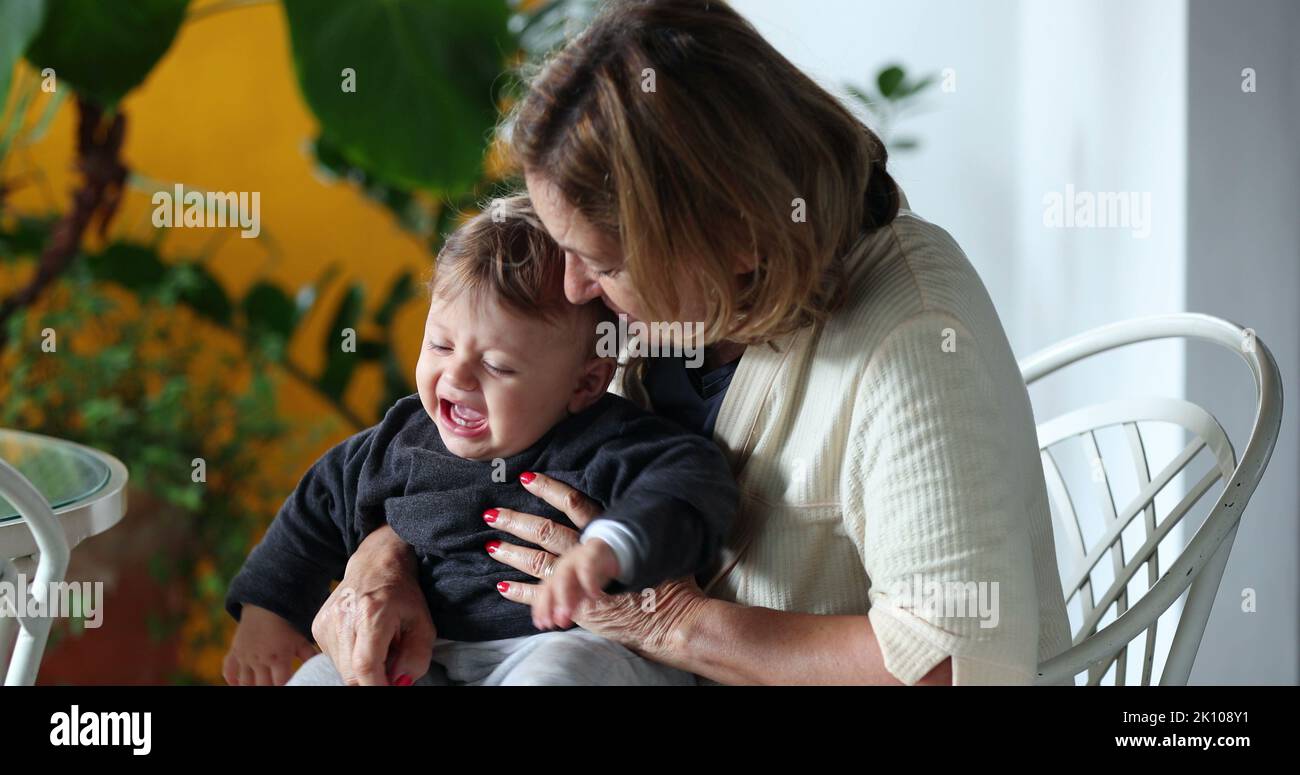 Grand-mère tenant bébé petit-fils en pleurs. Grand-parent essayant de console bébé tearful Banque D'Images