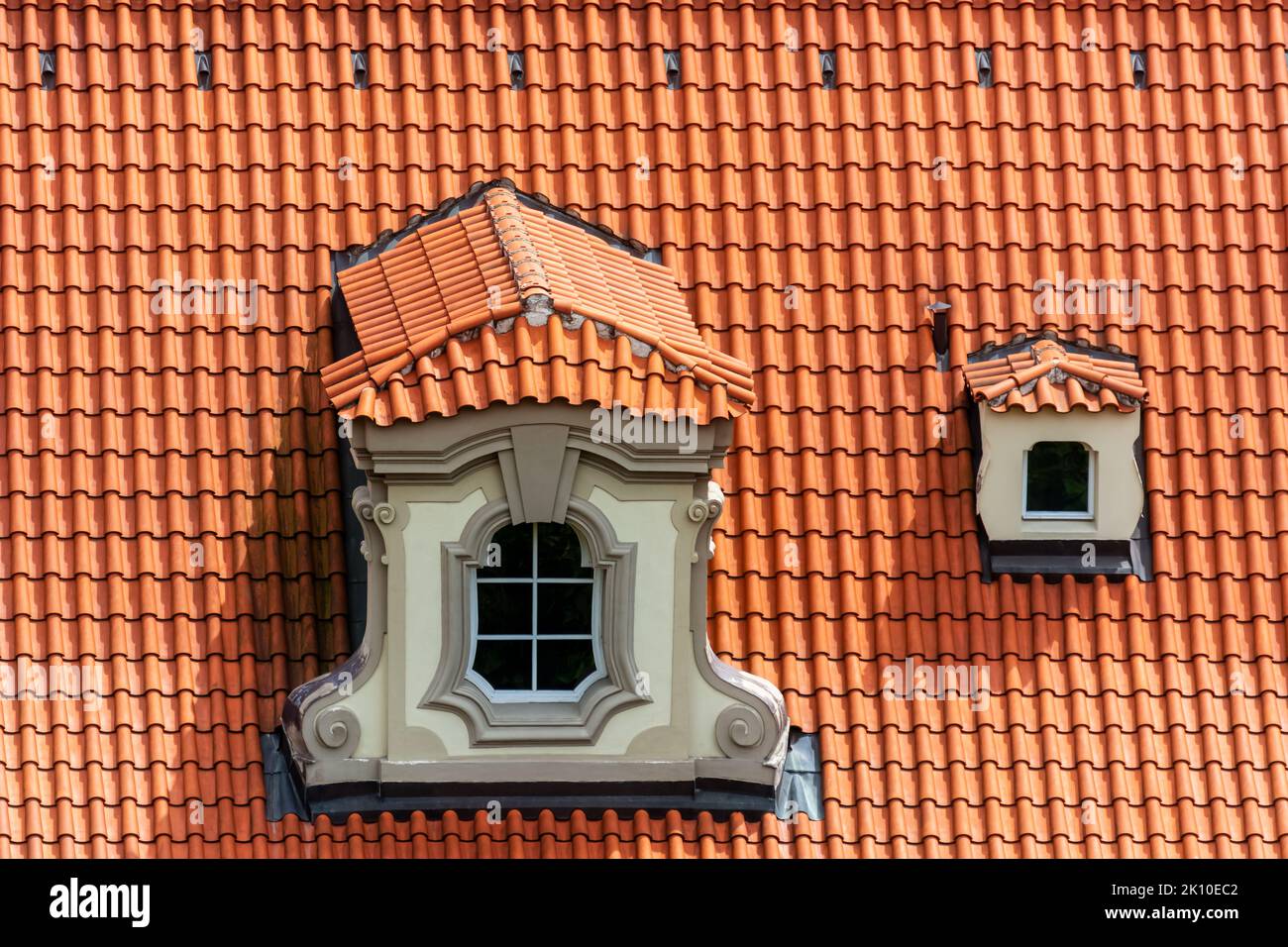 Petite mezzanine avec une fenêtre figurée sur un toit en tuiles rouges dans la ville tchèque de Prague. De la série fenêtre du monde. Banque D'Images