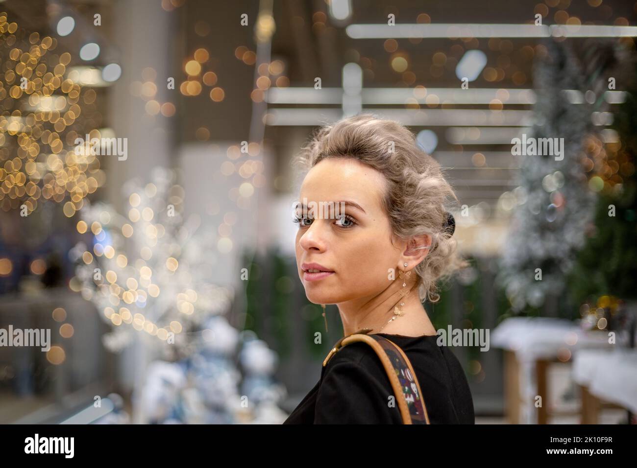 Une femme semble surprise et ravie avec les meilleurs espoirs pour l'avenir du nouvel an et les décorations de Noël dans le magasin Banque D'Images
