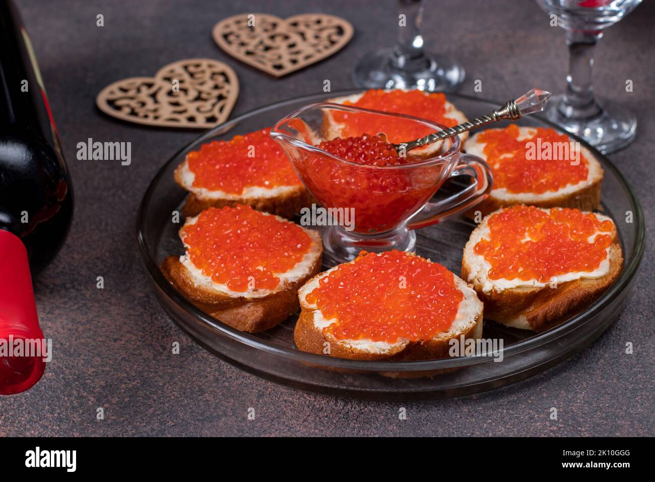 Sandwichs au caviar rouge sur pain blanc toasts sur plaque ronde sur fond marron, fête de la Saint-Valentin Banque D'Images