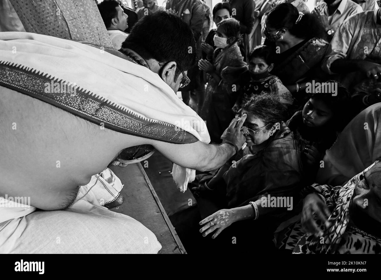 Howrah, Bengale-Occidental, Inde - 14th octobre 2021 : Hindu Purohit mettant le tilak Saint sur les fronts des dévotés pendant puppanjali puja à la déesse Durga. Banque D'Images