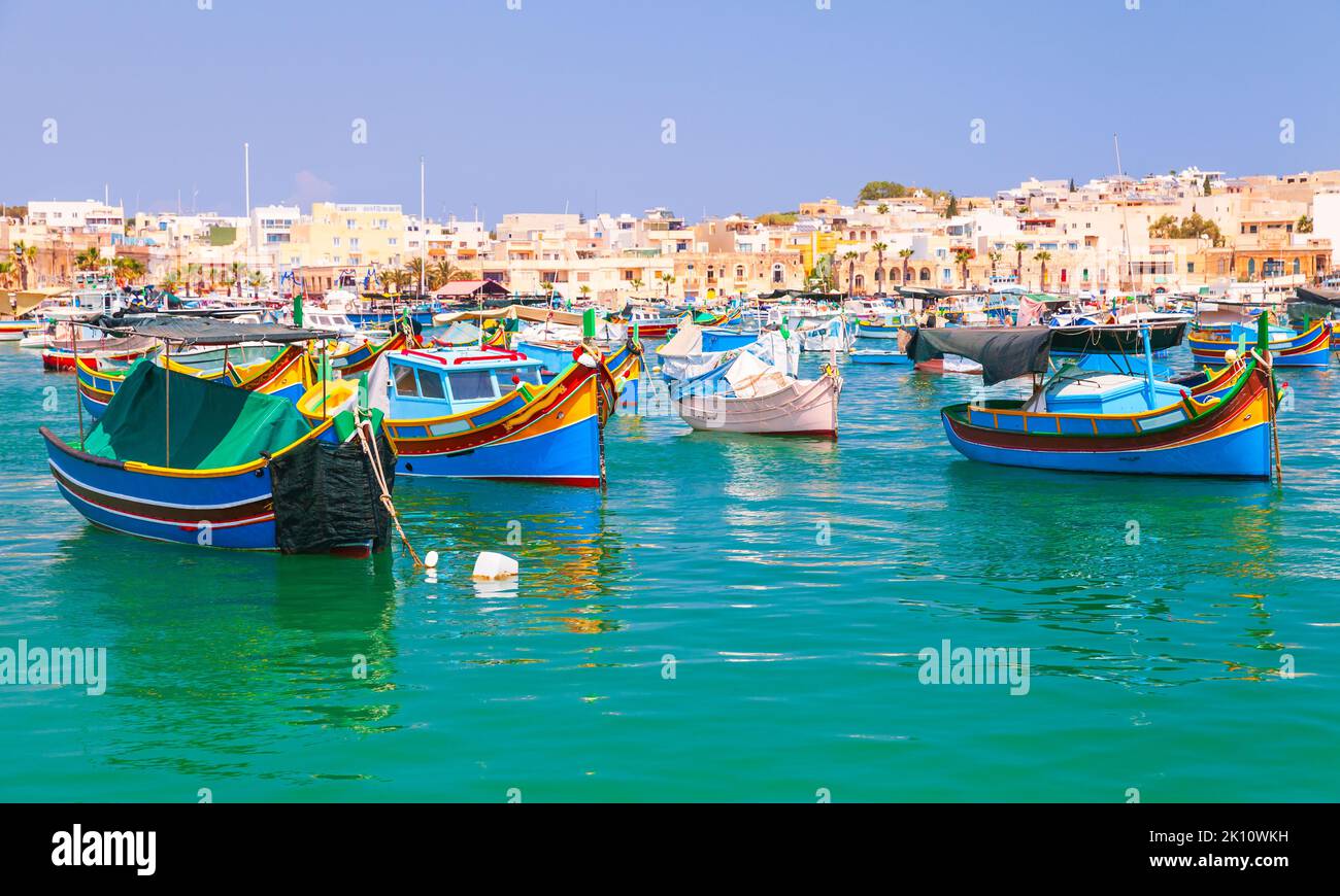 Des bateaux de pêche maltais traditionnels colorés sont amarrés dans le port de Marsaxlokk, à Malte Banque D'Images