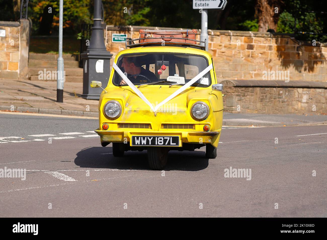 Une réplique de Trotters Yellow reliant Robin de la sitcom TV 'Only Fools & Horses' vu comme une voiture de mariage à Swillington, Leeds, Royaume-Uni Banque D'Images