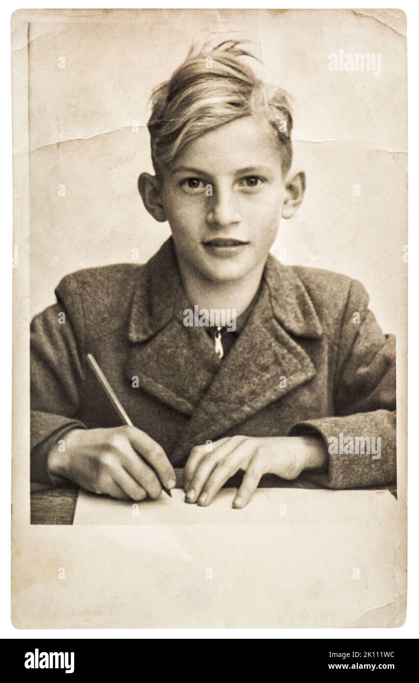 Vieille photo d'un garçon d'école. Image vintage avec grain original, flou et rayures Banque D'Images