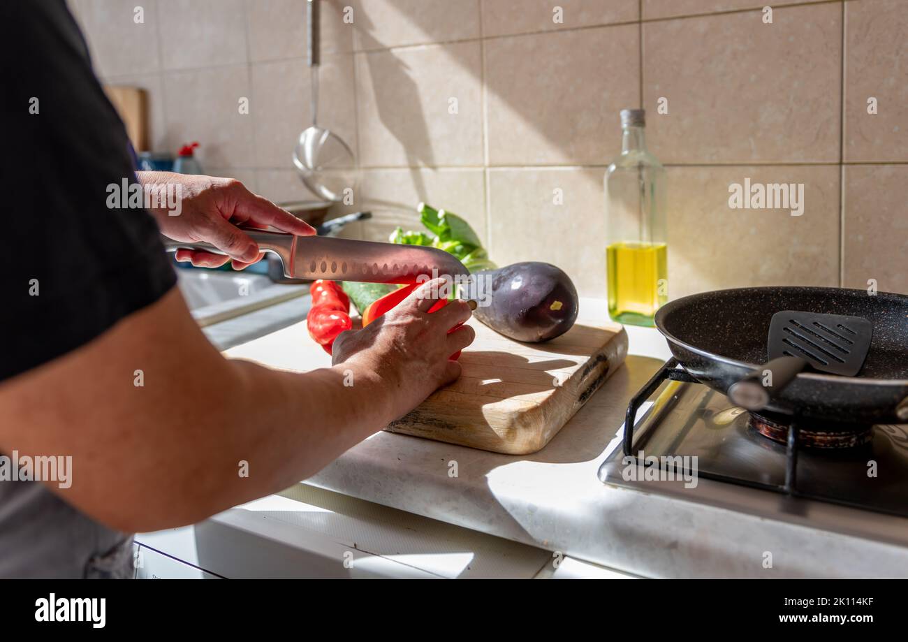 Une personne dans la cuisine préparant des légumes frais pour faire un repas délicieux et sain. Banque D'Images