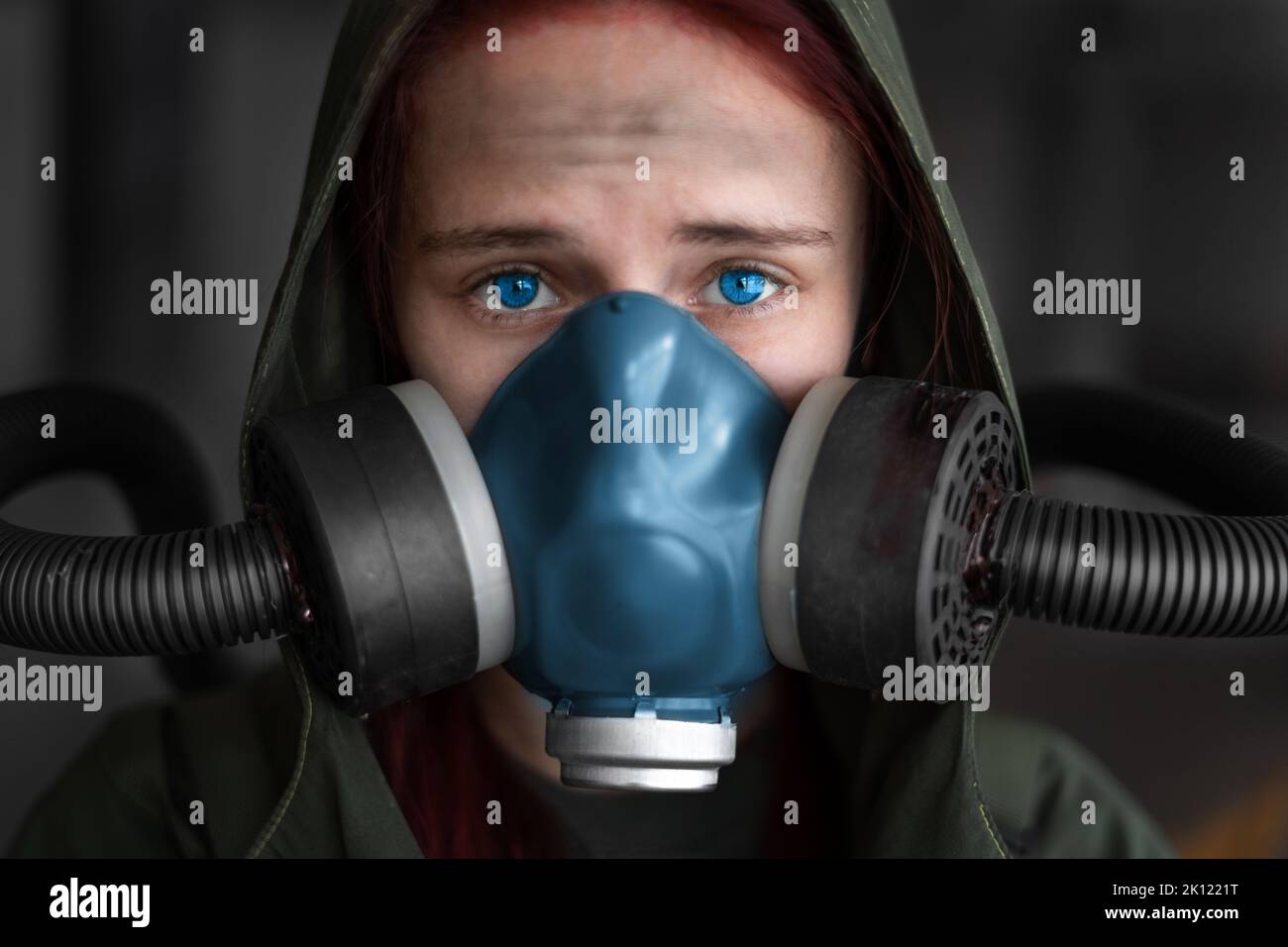 Post apocalypse femme survivante. Une jeune femme survit à une pandémie dans un masque à gaz, regardant en arrière-plan avec une zone de guerre apocalyptique arou Banque D'Images