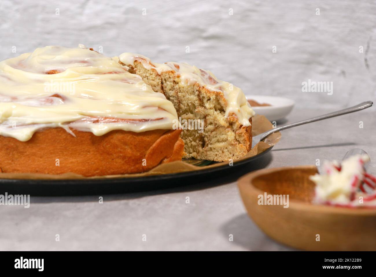 rouleau géant à la cannelle avec glaçage à la crème au beurre, table en marbre gris Banque D'Images