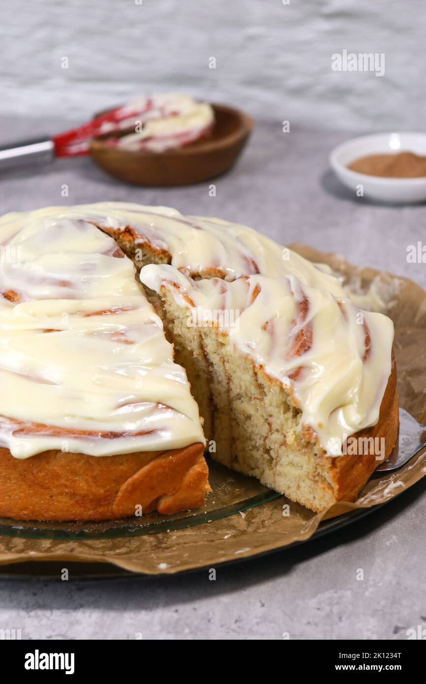 rouleau géant à la cannelle avec glaçage à la crème au beurre, table en marbre gris Banque D'Images