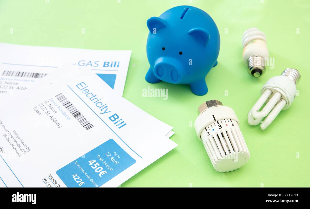 Concept d'augmentation et d'économie des coûts d'énergie et de chauffage. Factures d'électricité et de gaz, banque de porc, ampoule et thermostat de chauffage. Banque D'Images