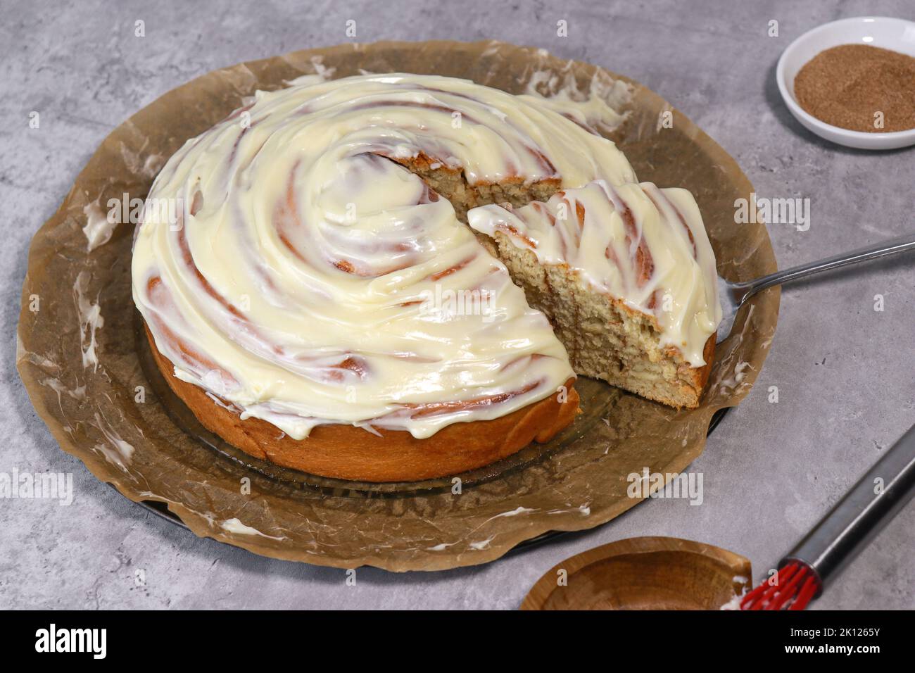 rouleau géant à la cannelle avec glaçage à la crème au beurre, table en marbre gris Banque D'Images