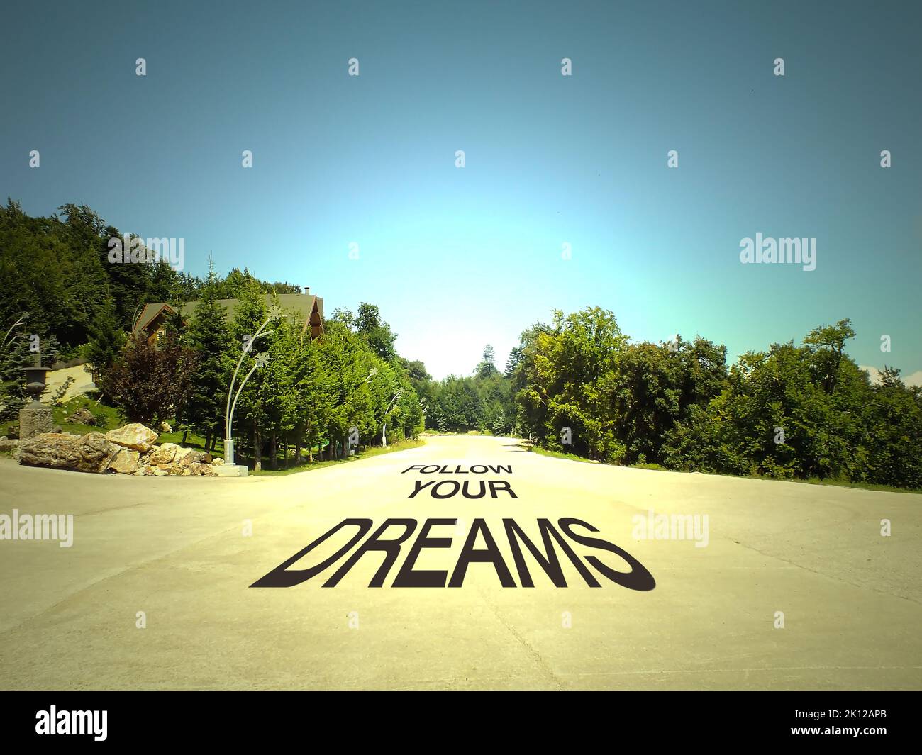 Suivez vos rêves écrits sur une route au milieu d'une route vide et beau concept de paysage. Banque D'Images