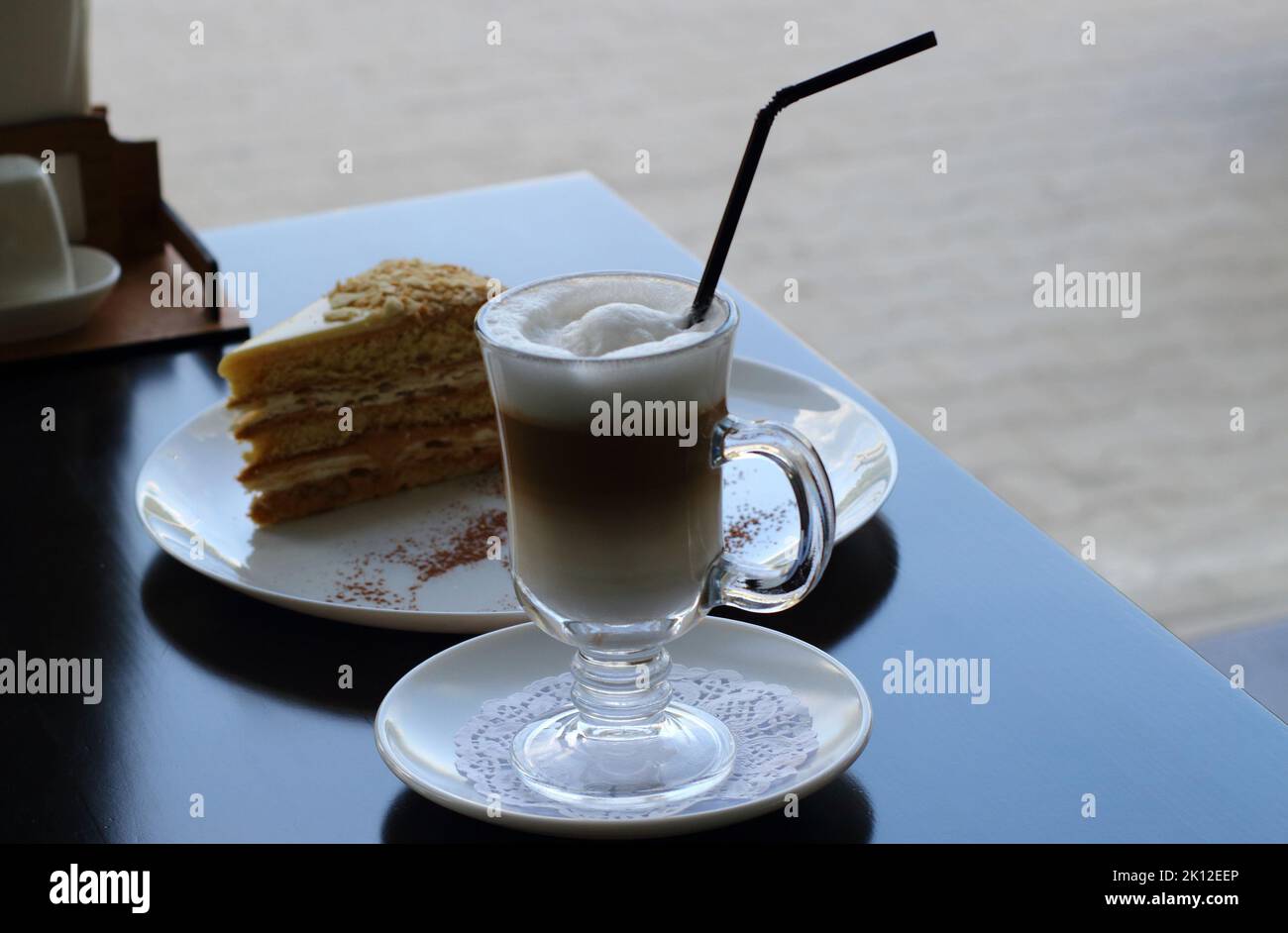 Pâtisserie douce et feuilletée, gâteau Napoléon et café au lait sur la table du bar du magasin de gâteaux Banque D'Images