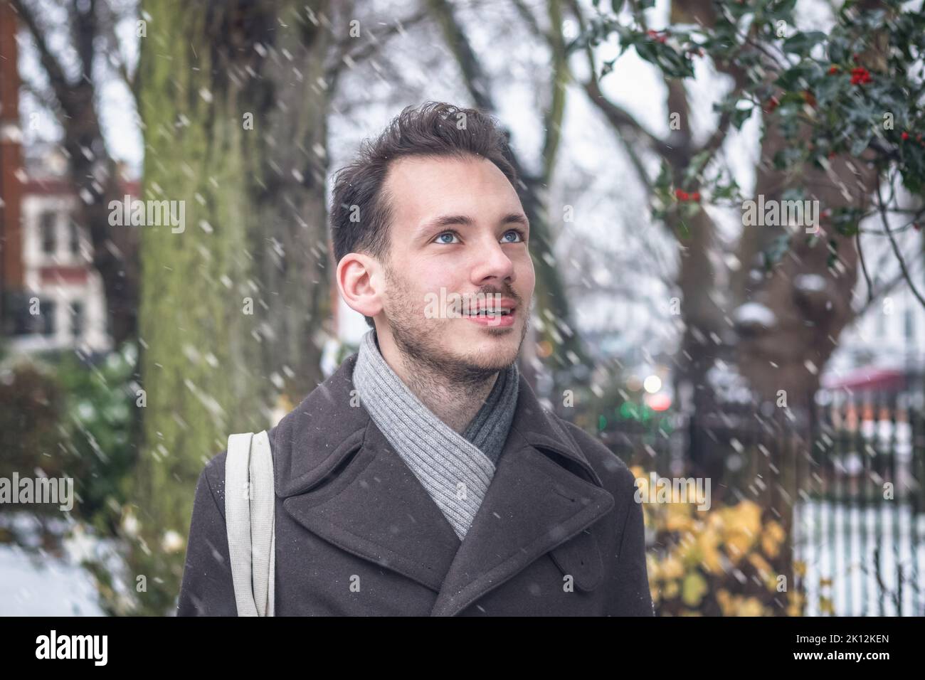 Portrait d'un beau jeune homme dans la neige d'hiver Banque D'Images