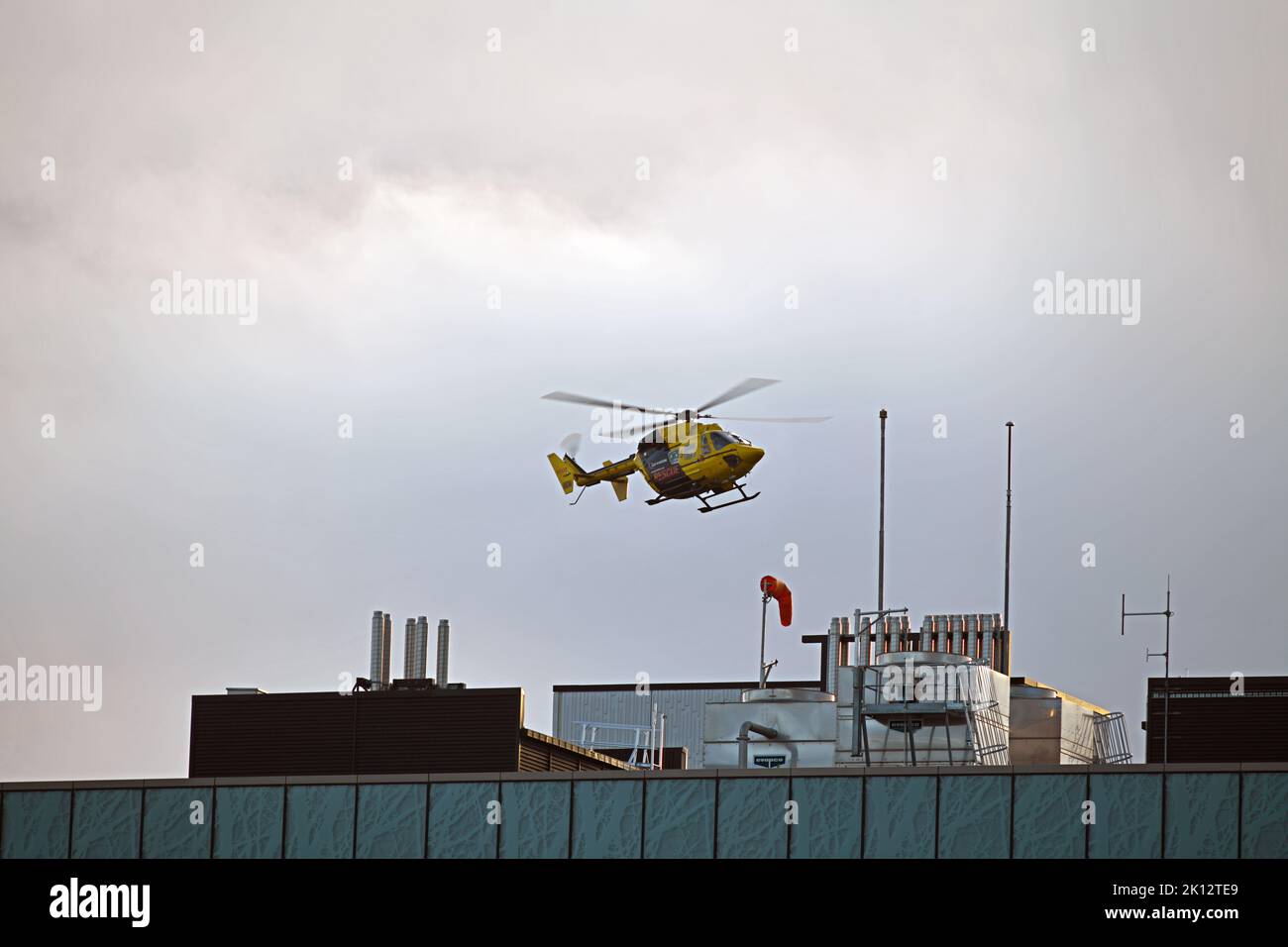 CHRISTCHURCH, NOUVELLE-ZÉLANDE, 8 SEPTEMBRE 2022 : un hélicoptère d'urgence atterrit au-dessus de l'hôpital général de Christchurch. Image granuleuse prise en basse lumière du soir. Banque D'Images