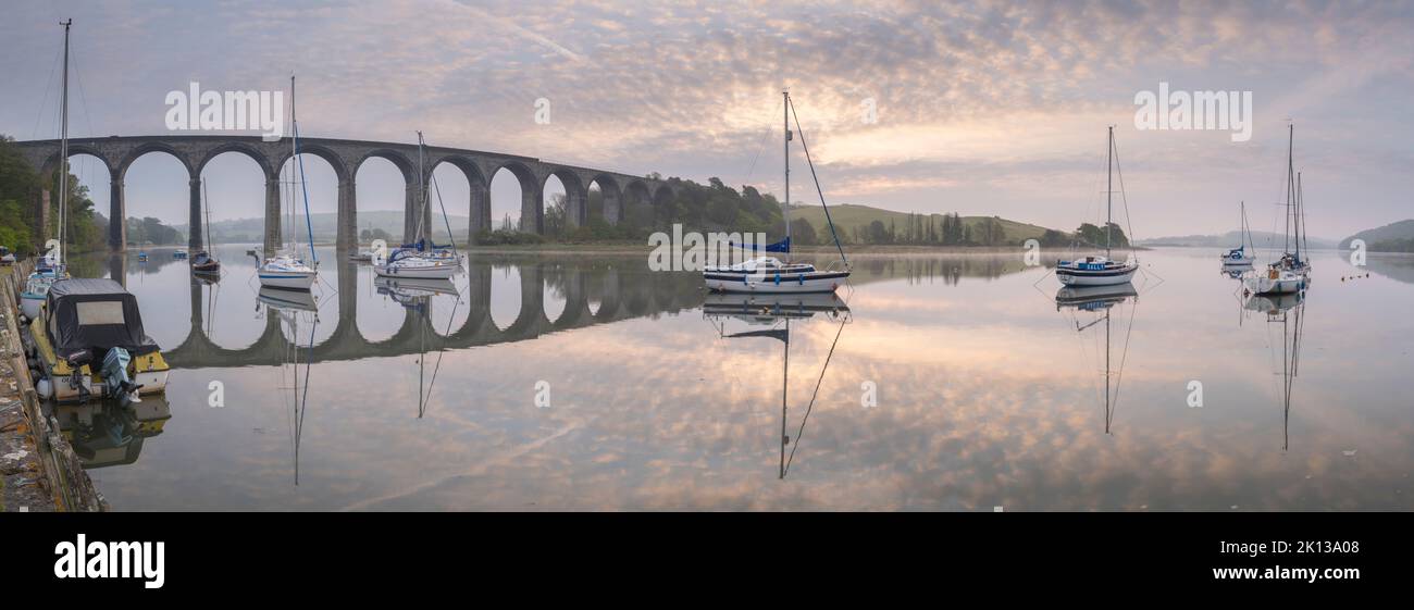 Bateaux amarrés sur la rivière Tiddy à l'aube sous le viaduc victorien à St. Allemands, Cornwall, Angleterre, Royaume-Uni, Europe Banque D'Images