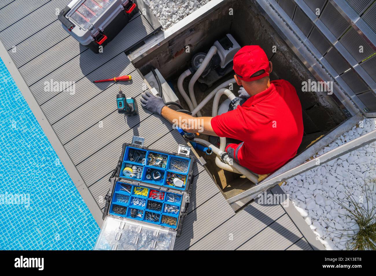 Nettoyage de la piscine extérieure et équipement de chauffage entretien saisonnier effectué par un technicien professionnel DU SPA en 40s. Banque D'Images