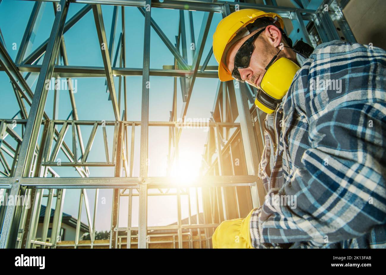 Gros plan photo d'un entrepreneur d'âge moyen caucasien penchée contre un mur avec une tête inclinée fatiguée après une journée de travail sur le site de construction. Acier Skel Banque D'Images