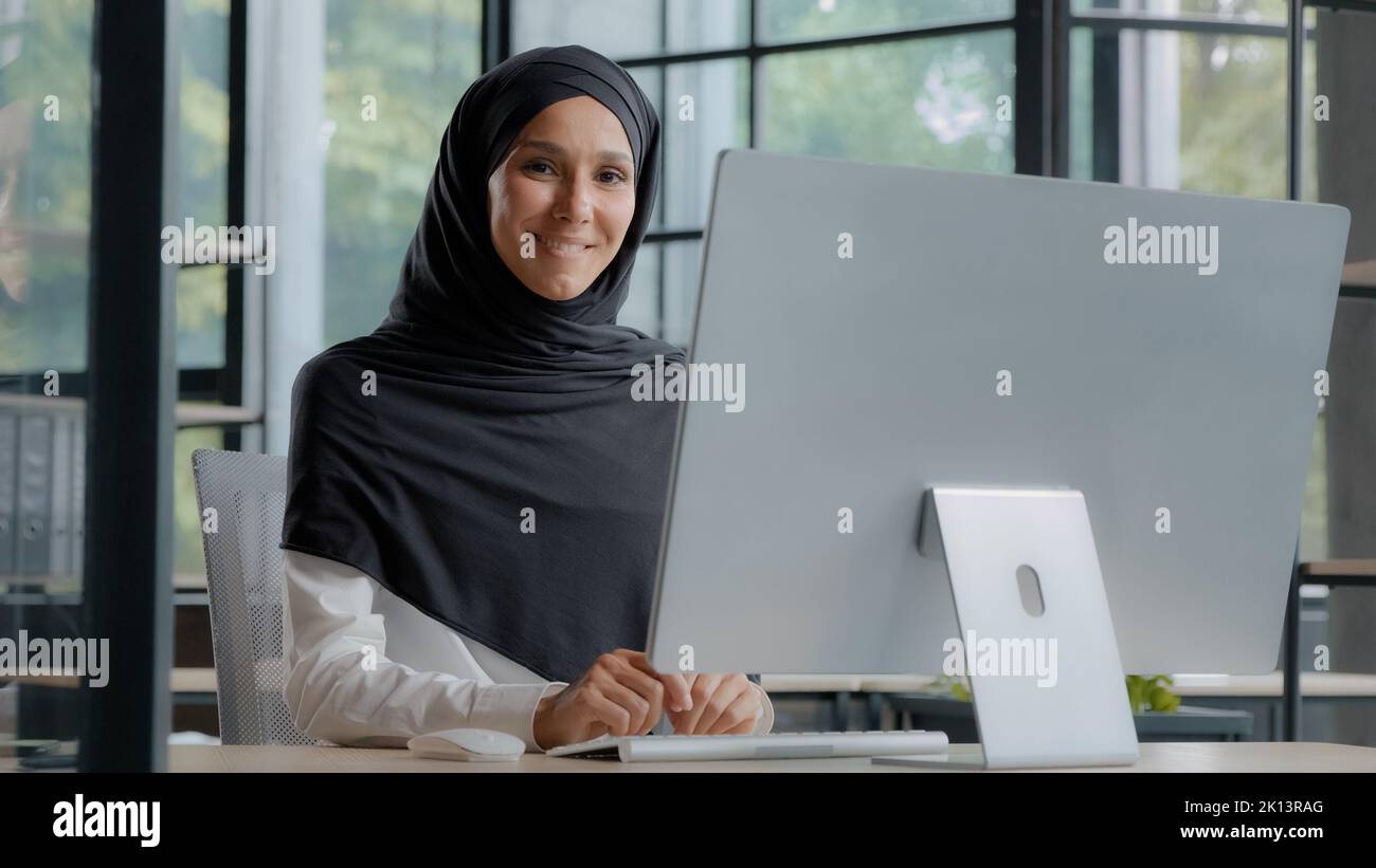 Confiante réussie élégante femme d'affaires arabe dactylographiant sur ordinateur attirante femme musulmane dans hijab travailleur professionnel cadre expérimenté Banque D'Images