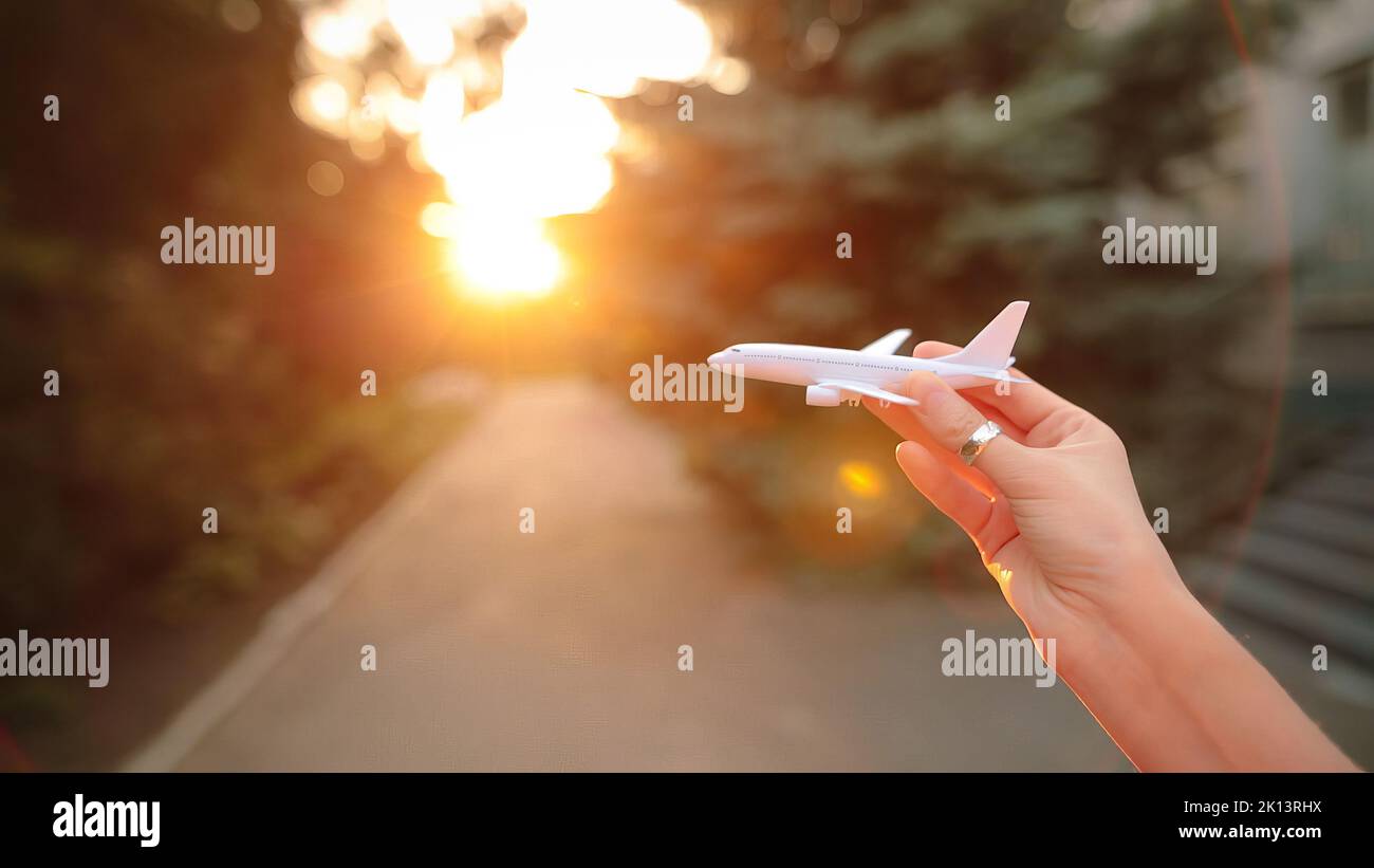 Un avion en plastique à la main simule un vol. Banque D'Images