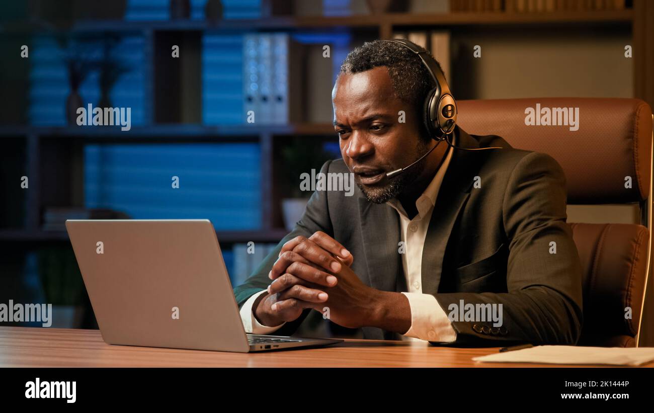 Le travailleur de bureau dans le casque communique avec le client sur le casque sur l'ordinateur portable homme psychologue parlant au patient par appel vidéo lors de la conférence en ligne Banque D'Images