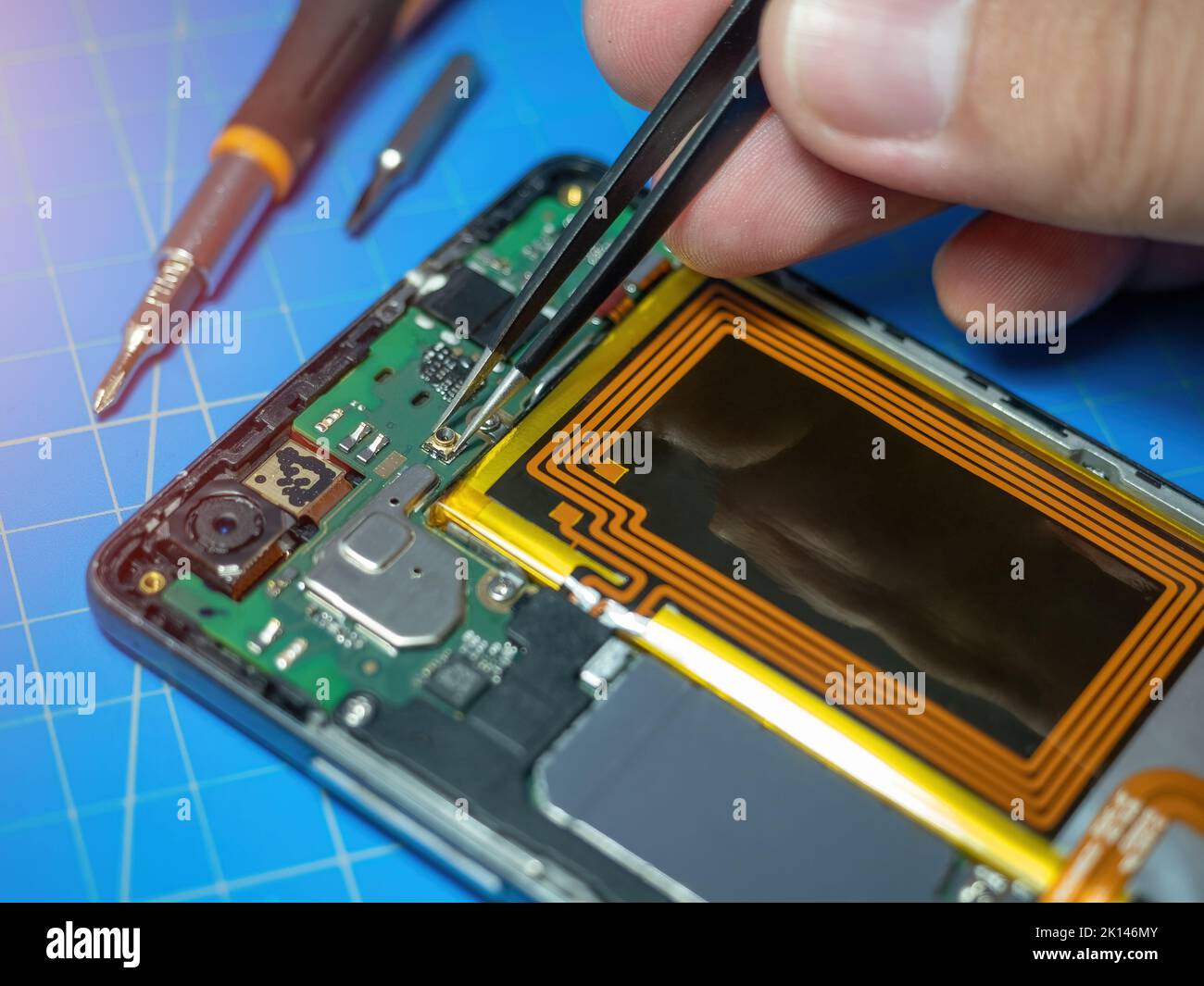 Un technicien de smartphone répare la carte mère d'un smartphone sur le bureau du laboratoire d'entretien. Concept de mise à niveau et de réparation du matériel électronique Banque D'Images