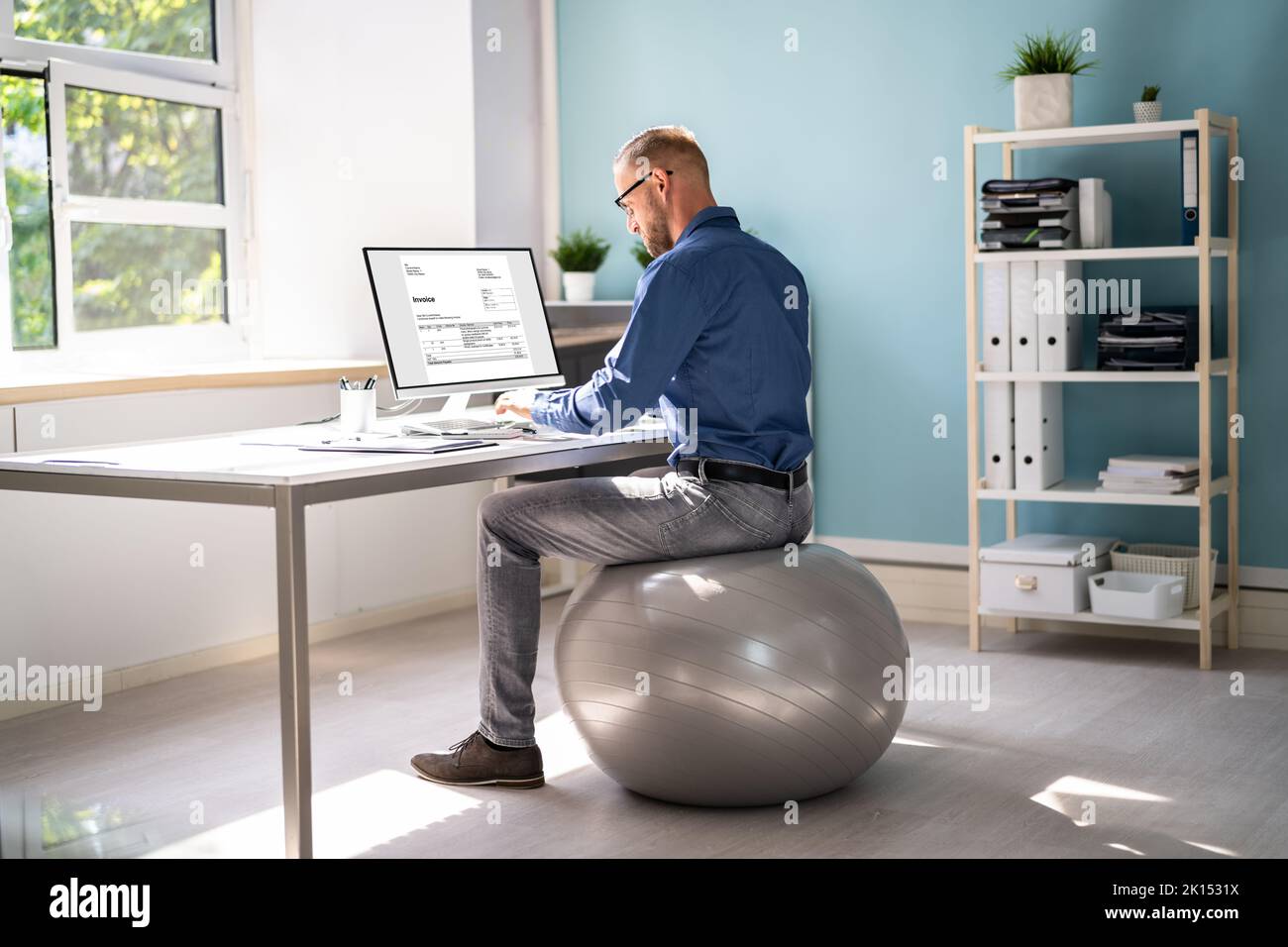 Posture correcte au bureau au bureau à l'aide d'un ballon de fitness Banque D'Images