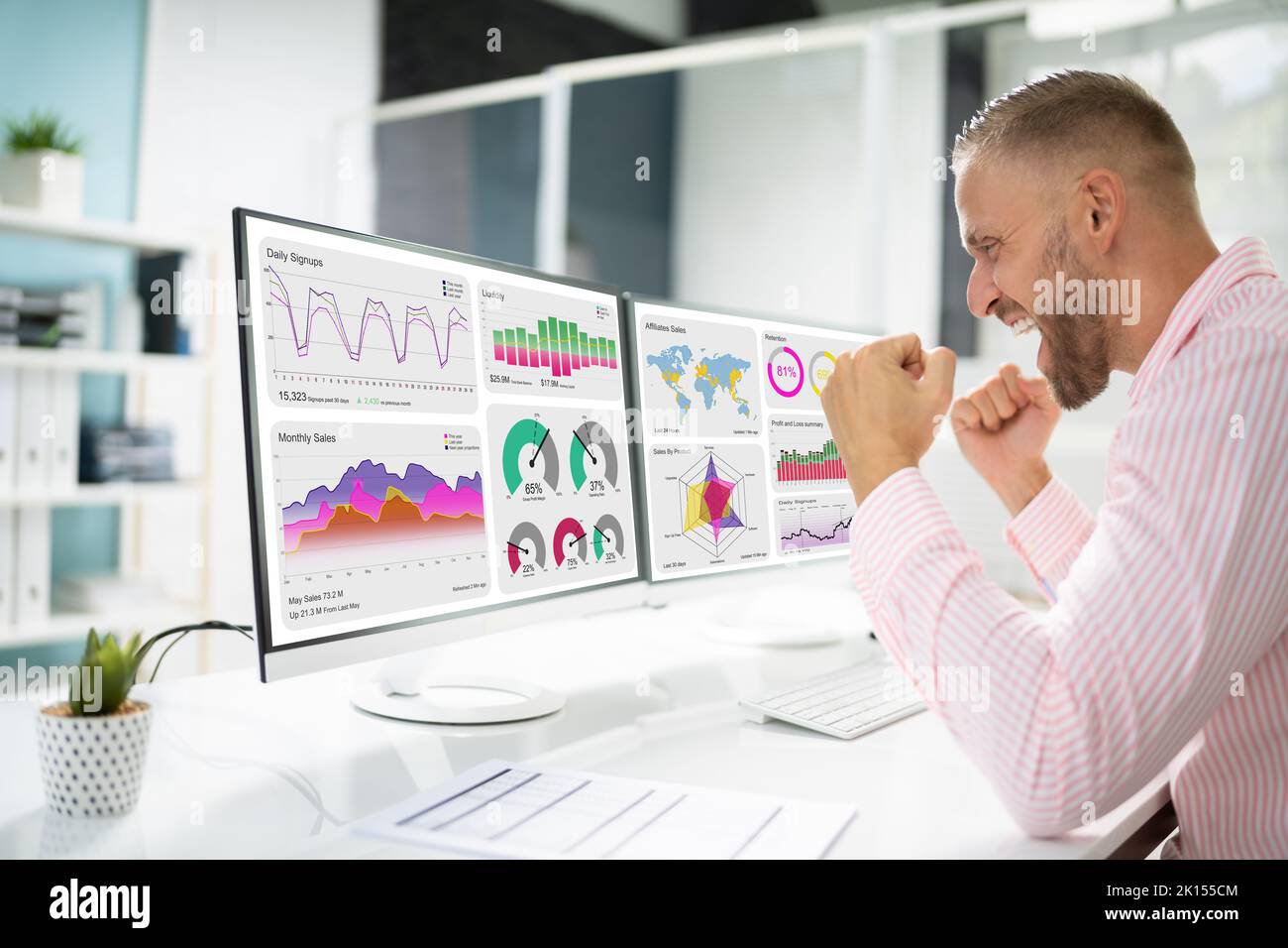 Analyste d'affaires enthousiaste utilisant le tableau de bord de données sur l'ordinateur et célébrant la victoire Banque D'Images