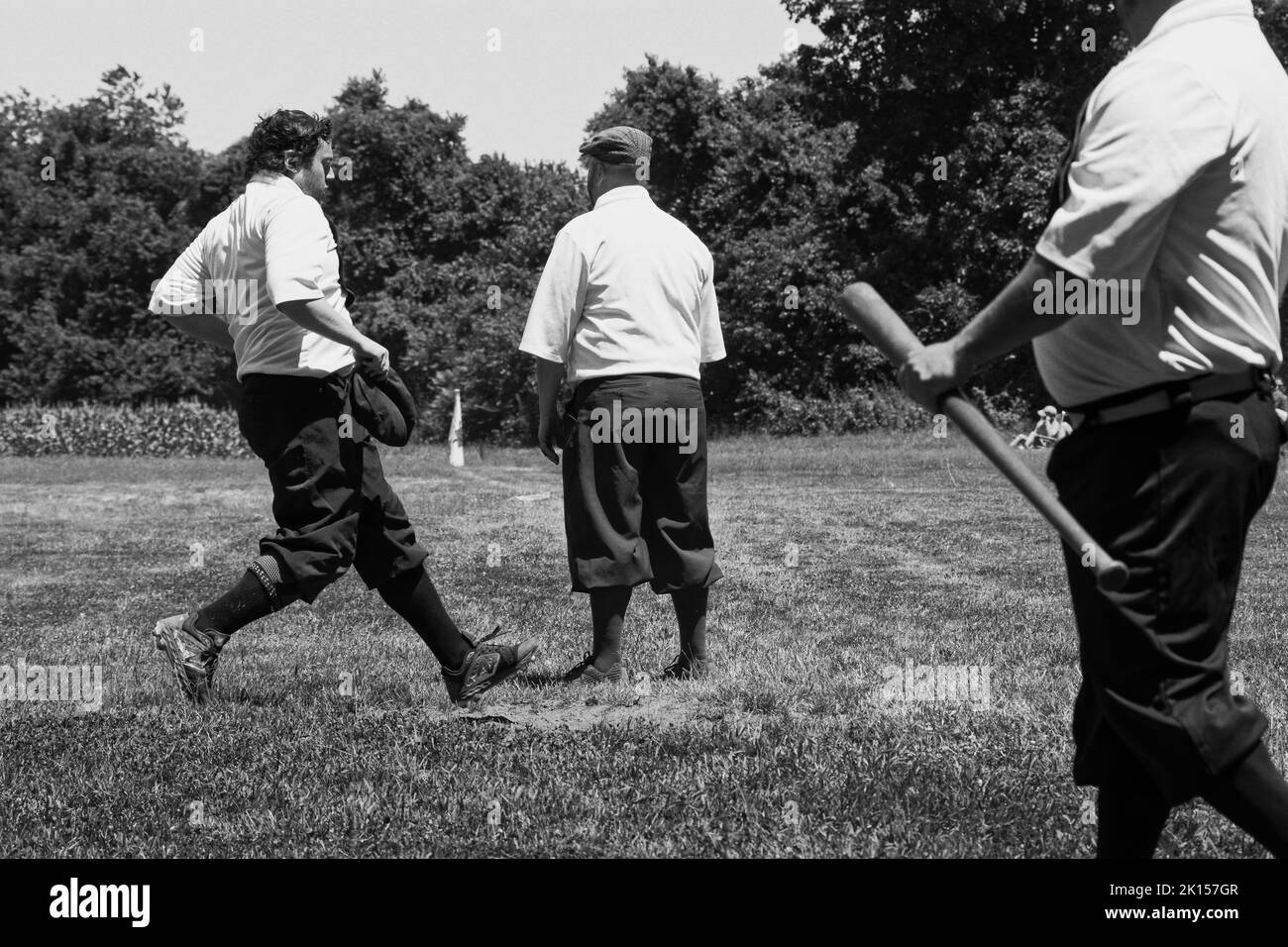 Un joueur de baseball touche l'assiette avec son orteil. Baseball d'époque avec 1860 règles jouées à la Spencer-Peirce-Little Farm - Newbury, Massachusetts. Banque D'Images