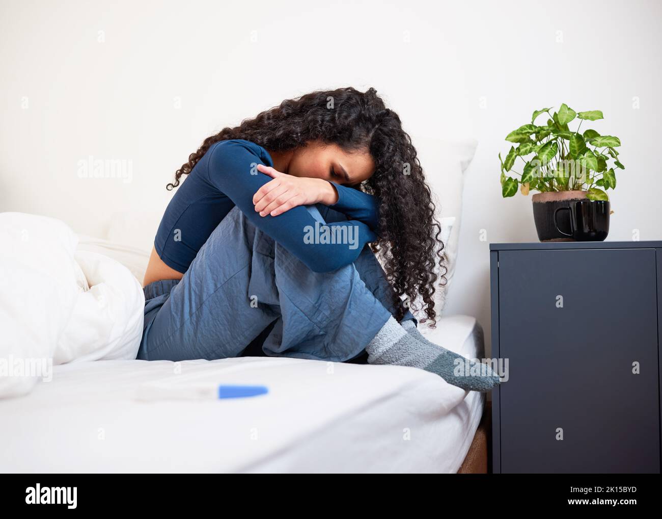 Une jeune femme multi-ethnique se trouve bouleversée et choquée au résultat du test de grossesse Banque D'Images