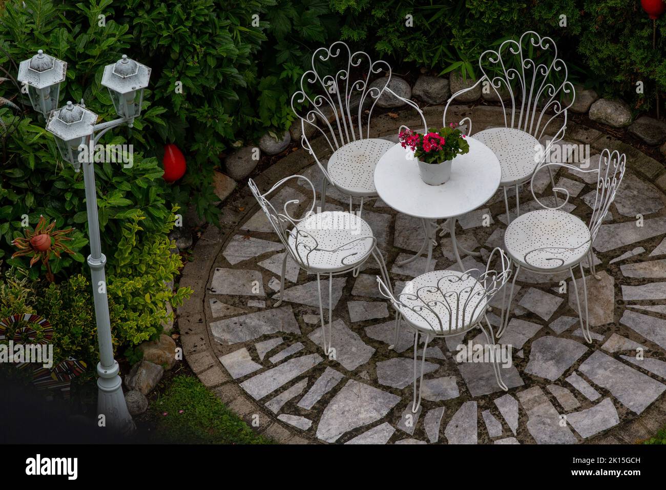 Image aérienne de la table extérieure et des chaises en fer forgé sur la terrasse en pierre dans le jardin avec pelouse et de grandes plantes autour, jardinage et l'aménagement paysager maison de Banque D'Images