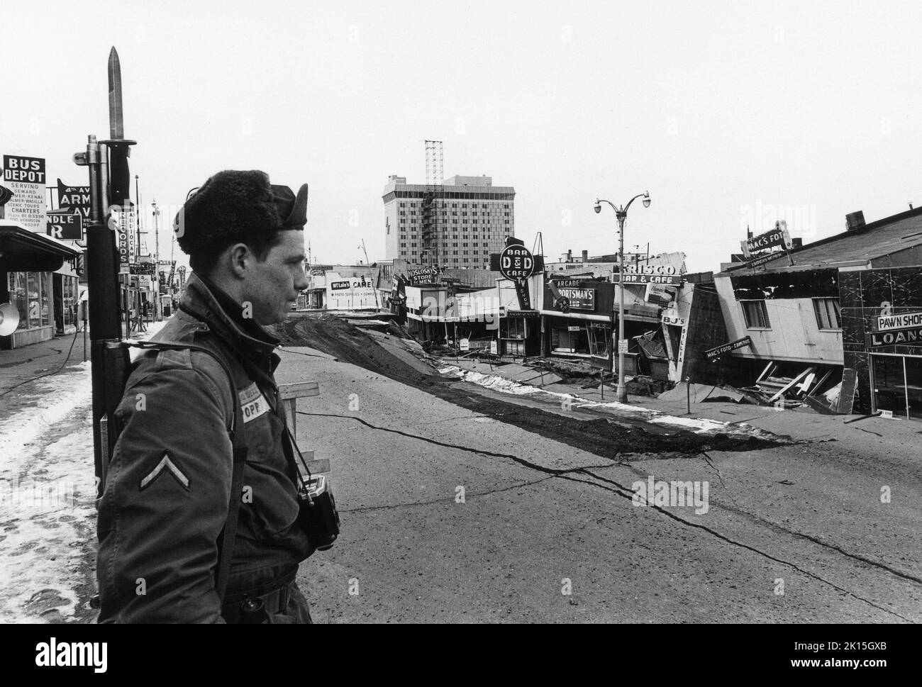 Un Guardsman national étudie la destruction qui a été causée dans le centre-ville d'Anchorage par le tremblement de terre de l'Alaska de 1964.À une magnitude de 9,2, il a été le plus puissant tremblement de terre enregistré dans l'histoire des États-Unis et de l'Amérique du Nord. Banque D'Images