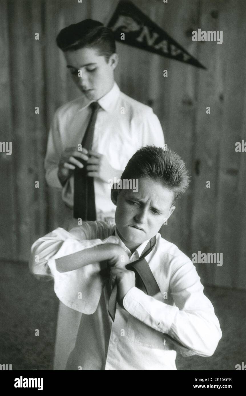 Un frère plus jeune imite le ficelage d'une cravate. Vers 1955. Banque D'Images
