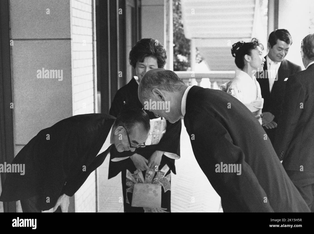 Le père de la mariée, l), et l'oncle du marié, r), échangent des arcs lors d'une réception de mariage à Tokyo; date inconnue. Banque D'Images