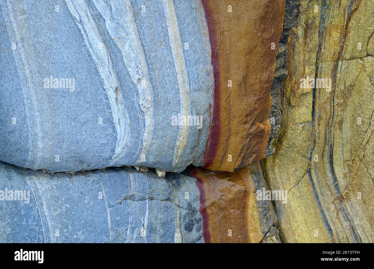 Fragment de surface rugueuse de mur rocailleux peint en bleu avec des rayures et des fissures comme arrière-plan texturé Banque D'Images