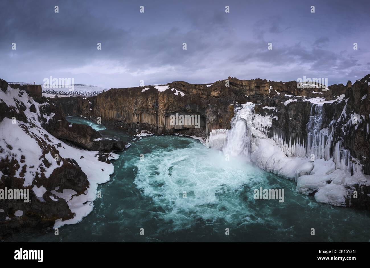 Vue pittoresque de drone de la cascade d'Aldeyjarfoss tombant d'une falaise de neige rugueuse contre ciel nuageux en soirée en hiver en Islande Banque D'Images