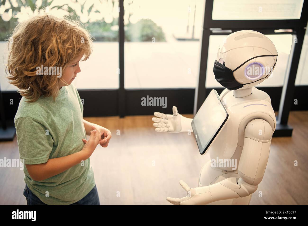 l'enfant concentré interagit avec l'intelligence artificielle de robot, la communication Banque D'Images