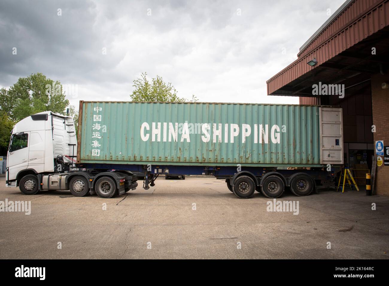 camion livrant des marchandises et des marchandises dans des conteneurs d'expédition, à un entrepôt d'une entreprise, watford , royaume-uni Banque D'Images