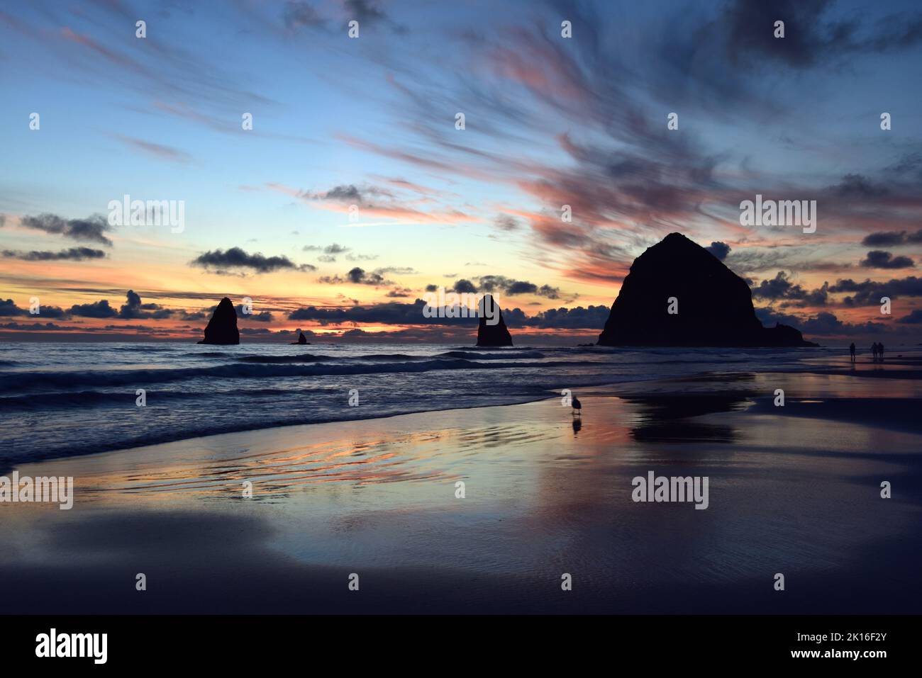 Un coucher de soleil coloré à Cannon Beach, Oregon, avec Haystack Rock dans Silhouette. Banque D'Images