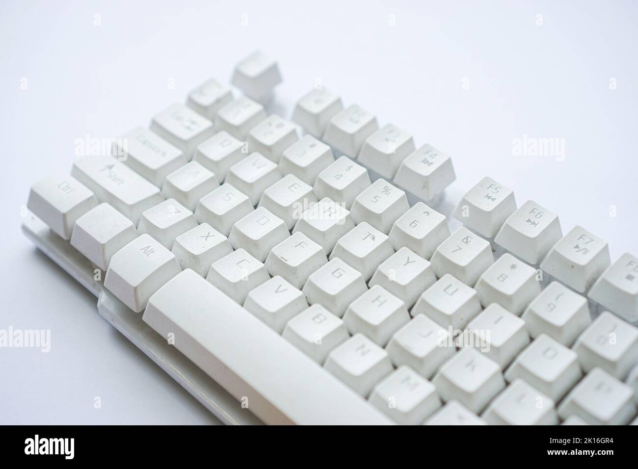 Utilisé clavier blanc d'ordinateur qui n'est pas utilisé jusqu'à ce qu'il soit isolé de poussière sur blanc Banque D'Images