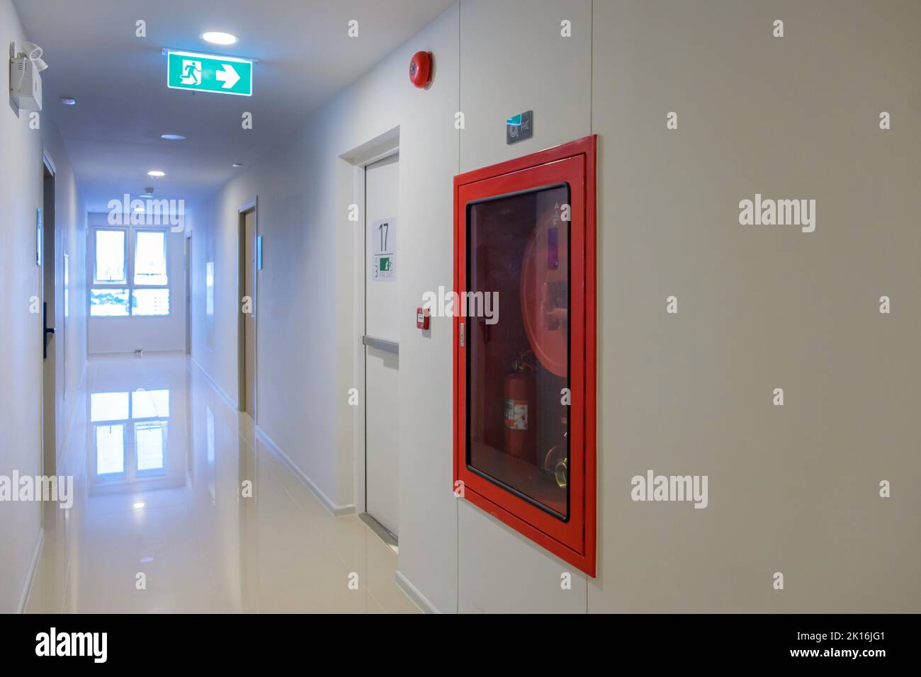 Système d'extincteur sur le mur avec panneau de porte de sortie de secours pour les urgences. Un incendie d'escalier pour s'échapper dans un bâtiment ou un appartement Banque D'Images