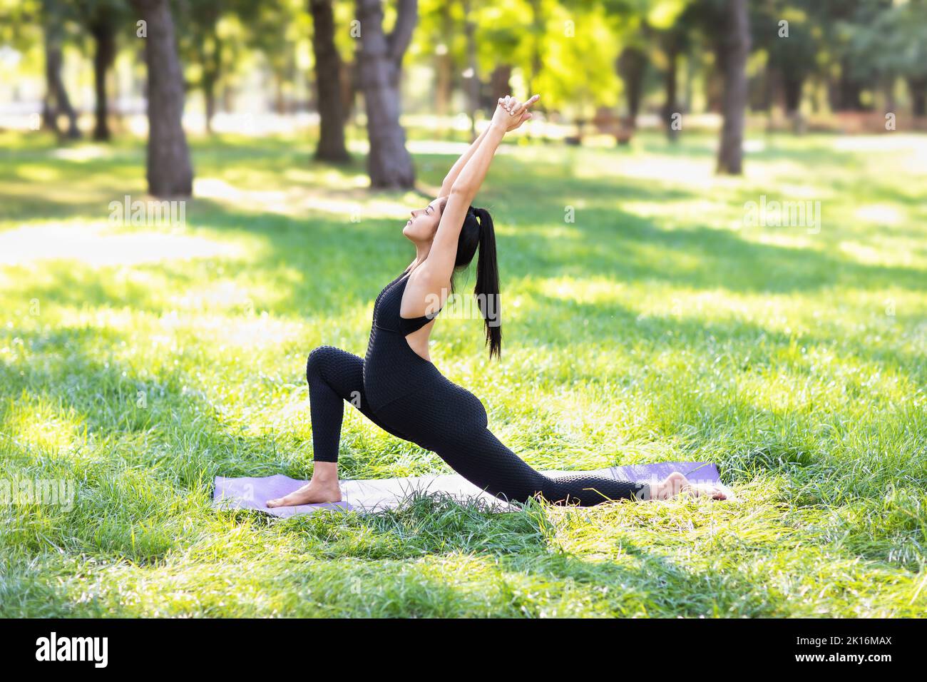 Jeune femme enceinte pratiquant le yoga faire Ashwa sanchalanasana exercice, pose de pilote, faisant le renforcement du corps dans le parc sur un matin ensoleillé d'été o Banque D'Images