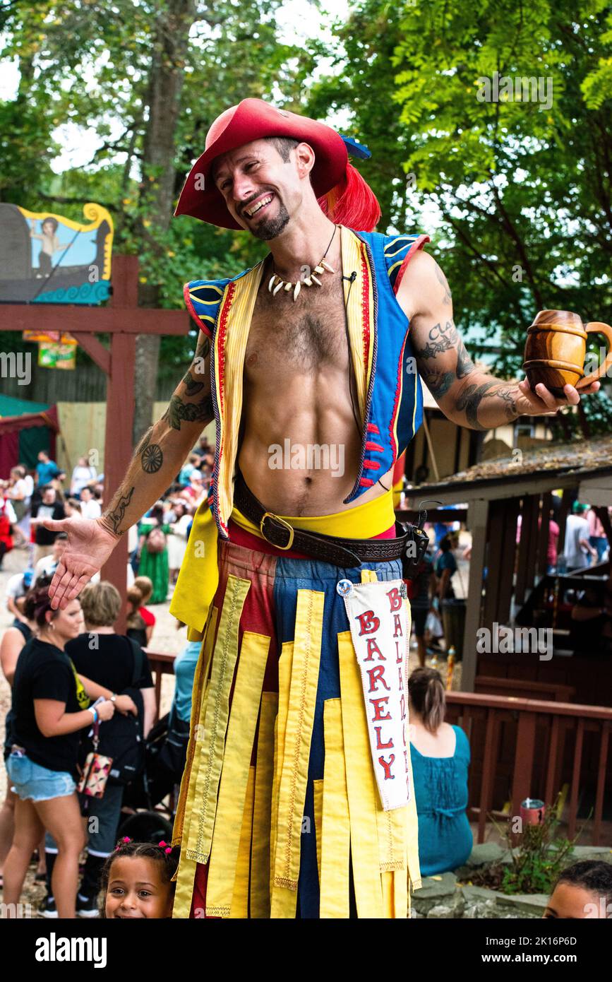 Stilt Walker de la troupe acrobatique à peine équilibrée, Maryland Renaissance Festival 2022.format vertical, en interaction avec la foule. Revel Grove, Tudor. Banque D'Images