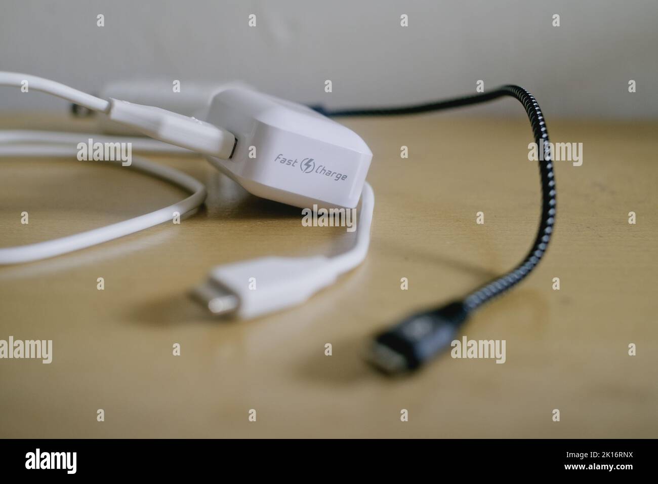Chargeurs de téléphones portables à chargement rapide noir et blanc pour téléphones Android avec câbles de données USB vers micro USB amovibles sur la table. Mise au point sélective. Banque D'Images