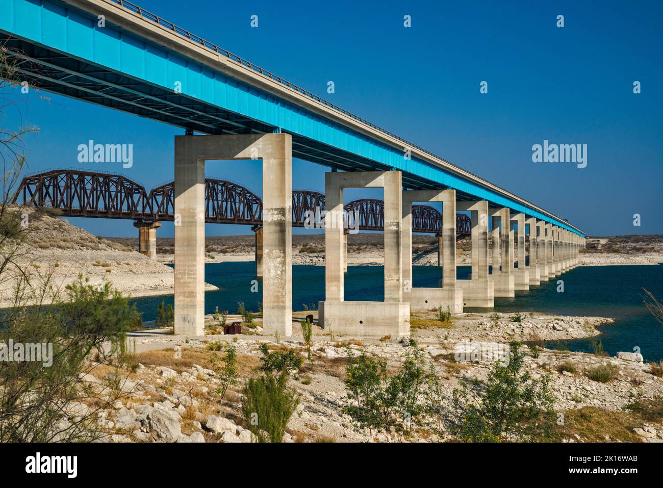 PONT ROUTIER ET ferroviaire US-90 traversant le réservoir Amistad, niveau d'eau très bas en avril 2022, marques de haut niveau visibles sur les jetées, près de Del Rio, TX Banque D'Images