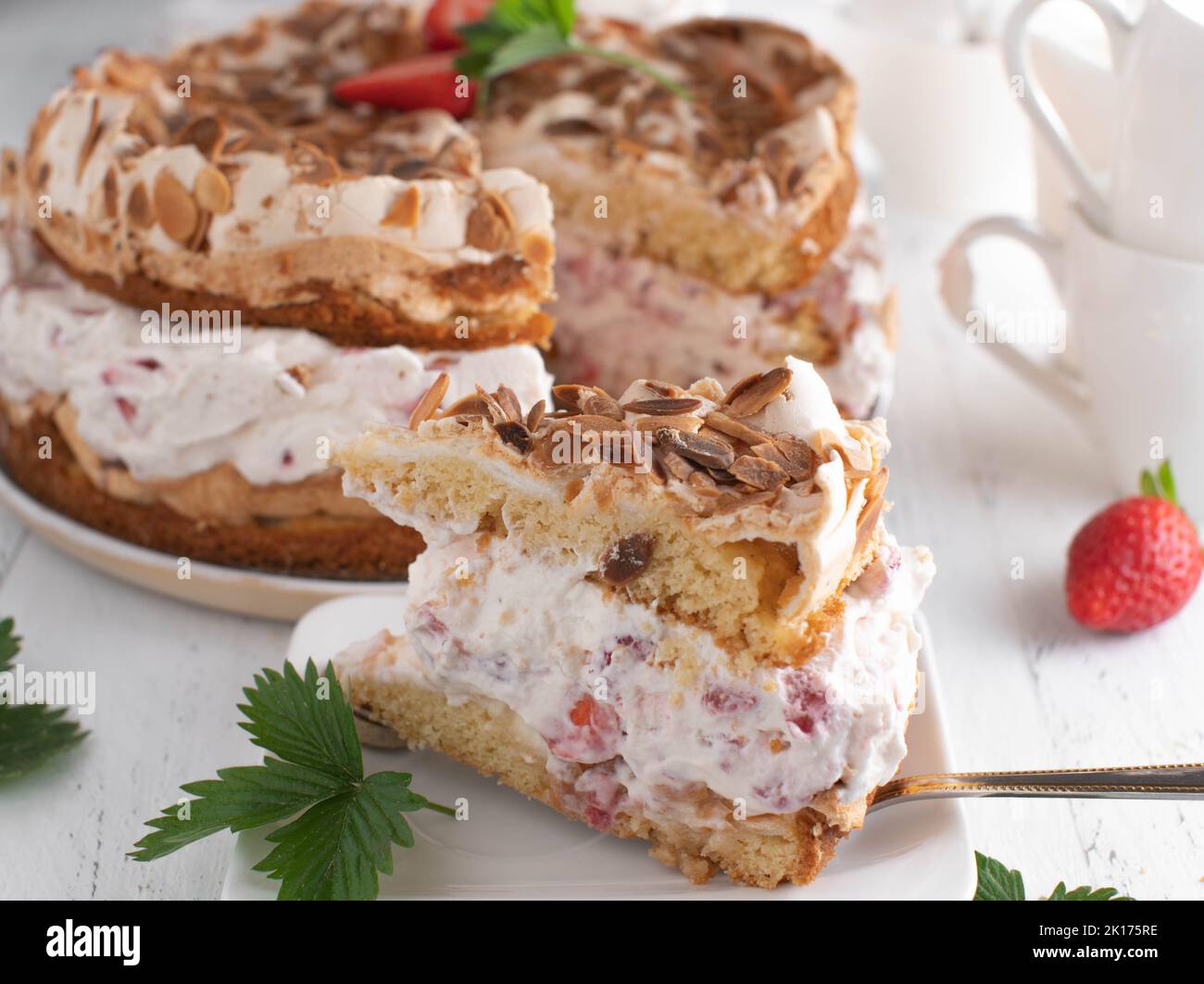 Gâteau à la crème fraise avec meringue, garniture aux amandes. Dessert allemand traditionnel Banque D'Images