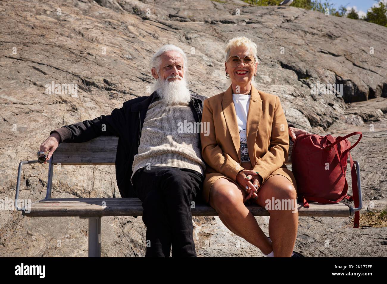 Couple souriant assis ensemble sur le banc Banque D'Images